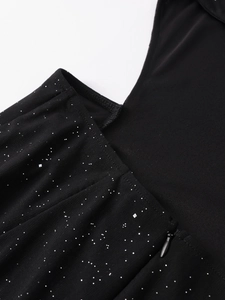Detail view of black mesh dress featuring silver glitter flakes and an invisible side zipper