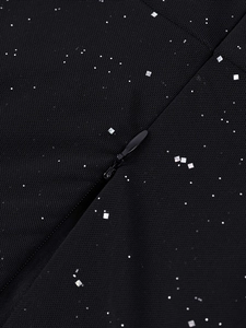 Détail du tissu en maille noire avec paillettes argentées et fermeture éclair invisible