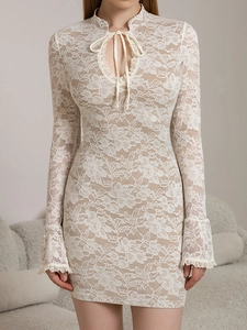 Detail of white lace dress showing trumpet sleeves and eyelash lace trim texture