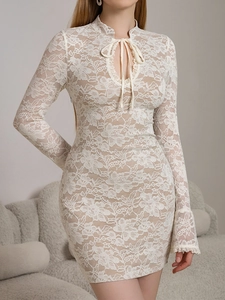 Close-up of intricate white floral lace texture and flared sleeve detail on dress