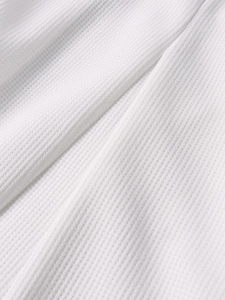 Close-up of white waffle knit fabric texture showing high-quality breathable detail
