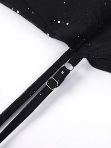 Détail de boucles métalliques réglables sur robe en tulle noir à paillettes argentées