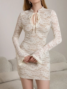 Close-up of white lace dress featuring flared sleeves and tie-up neckline detail