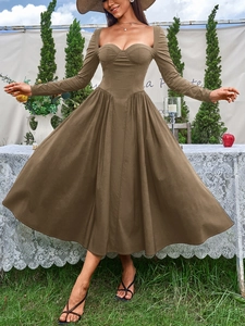 Détail d'une robe mi-longue kaki à manches longues avec coutures bustier et jupe plissée évasée