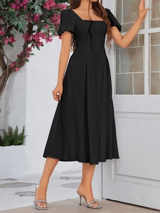 Detail of elegant black square neck dress with puff sleeves and A-line skirt fit