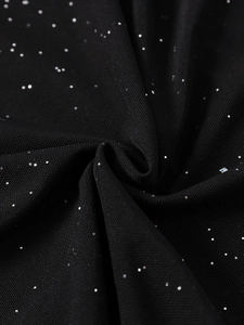 Detailed close-up of sparkling black mesh fabric with silver glitter sequins and soft folds
