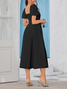 Detail of smocked back and square neck on a black mid-length dress with puff sleeves