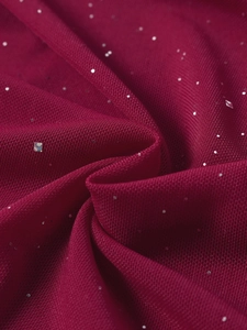 Detailed macro view of burgundy mesh fabric with sparkling silver sequins and glitter texture