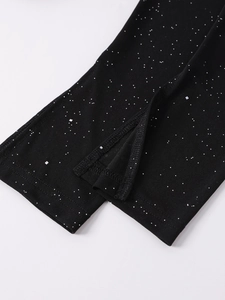 Detailed macro shot of the black mesh sleeve with silver glitter dots and slit hem detail