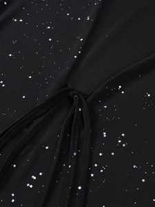 Vue macro du tissu en maille noire avec paillettes argentées et détail de nœud élégant