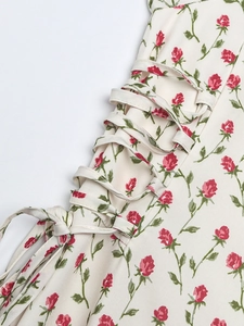 Détail de la robe à imprimé roses rouges avec laçage latéral et nœud élégant