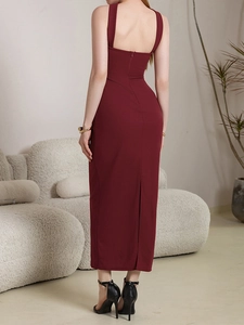 Detail of burgundy backless midi dress featuring a vertical hidden zipper and back slit