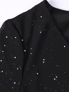 Détail macro du tissu en résille noire avec sequins carrés argentés et texture effet étoilé