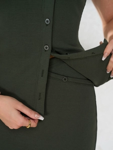 Detailed close-up of dark green ribbed knit fabric and matching resin buttons on a skirt set