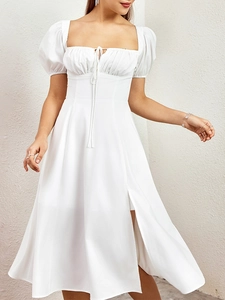 Détail de l'encolure carrée et du buste froncé avec cordon sur cette robe d'été blanche