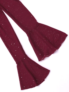 Close-up of mesh fabric with silver glitter and flared sleeve detail on dark red dress