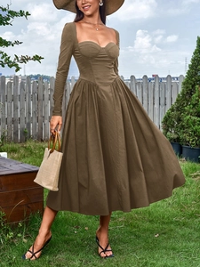 Gros plan du décolleté en cœur carré et du corsage plissé d'une robe mi-longue taupe