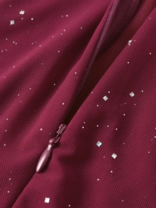 Close-up of wine red mesh fabric with silver sequins and hidden zipper on dress