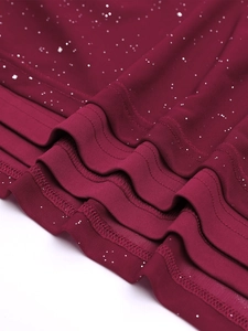 Close-up of wine red mesh dress hem with silver glitter sequins and wavy layered edges