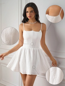 Detailed macro view of white floral jacquard texture and scalloped lace trim on a mini dress