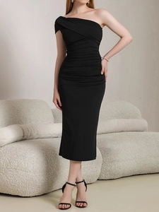 Détail des fronces sur une robe mi-longue noire à une épaule pour une coupe élégante