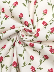 Vue macro du tissu élastique à imprimé roses rouges avec un élégant drapé de robe