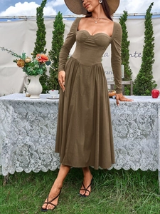 Gros plan du décolleté carré et du corsage ajusté de cette robe trapèze marron