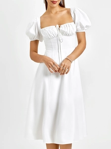 Détail de la robe blanche à manches bouffantes avec décolleté plissé à cordon