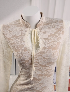 Detail of floral crochet lace top featuring a mandarin collar with teardrop cutout and ties