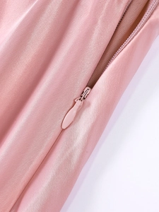 Close-up of a pink satin dress with a hidden zipper and high-quality stitching detail