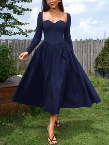 Détail d'une robe longue bleu marine à manches longues avec décolleté en cœur structuré