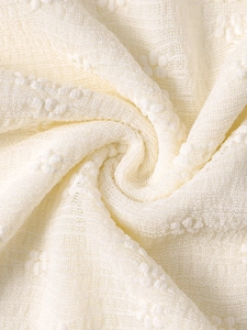 Detailed close-up of beige lace fabric with 3D embossed dots and soft mesh texture