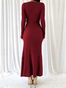 Détail du tissu texturé rouge foncé et silhouette sirène ajustée sur la robe longue