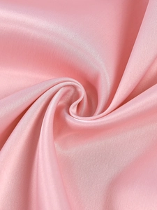Macro detail of high-quality pink satin fabric with smooth texture and soft silk sheen