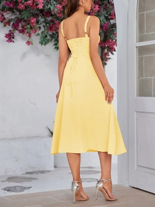 Detail of yellow corset-style back tie and flowy A-line skirt on a long dress