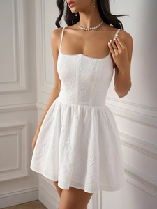 Detailed view of floral embroidery and lace trim on a white corset-style mini dress