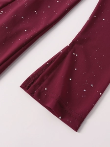 Detail of burgundy mesh dress sleeve with sparkling silver sequins and fine stitching