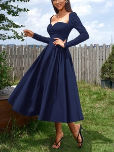 Détail de la robe bleu marine à manches longues avec décolleté en cœur et style corset