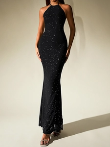 Détail d'une robe sirène dos nu avec des paillettes argentées sur un tissu en maille noire