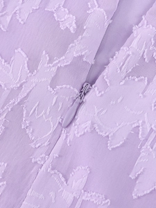 Détail du tissu jacquard violet avec texture de feuilles et fermeture éclair invisible