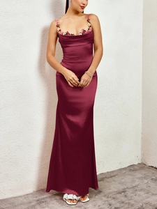Détails de broderie sur robe longue en satin bordeaux avec appliqués floraux et bretelles