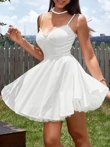 Detailed view of white mini dress featuring delicate lace trim and multi-layer pleated hem