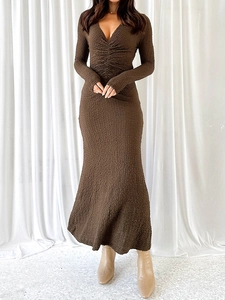 Détail du col en V et texture froncée sur robe longue en maille marron à manches