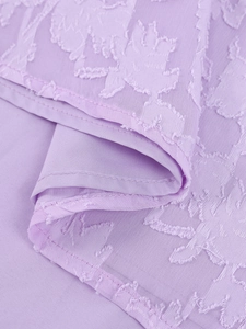 Gros plan détaillé du tissu jacquard violet avec motifs floraux et finitions de couture
