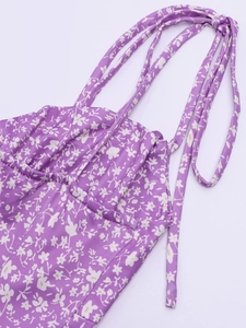 Détail du tissu en soie de lait violette avec motif floral blanc et texture élastique