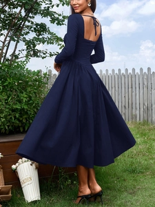 Détail du dos nu avec nœud papillon sur une robe mi-longue à manches longues bleu marine