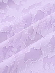 Détail macro du tissu jacquard lavande avec textures florales et plis délicats