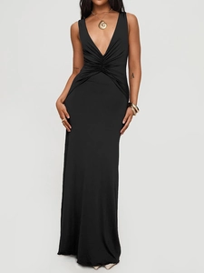 Detail of elegant black deep V-neck dress with ruched waist and gold shell pendant