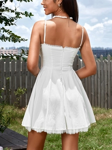 Detail of white mini dress featuring back invisible zipper and lace-trimmed neckline