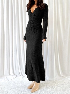 Gros plan détaillé de la robe noire à manches longues et col en V avec texture plissée